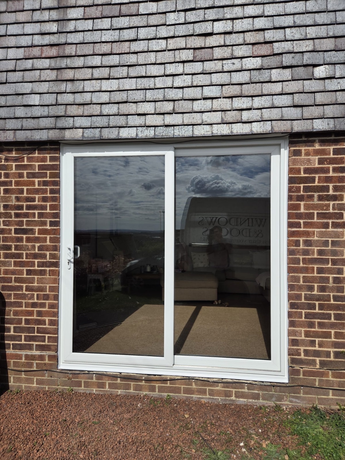 Sliding patio door fitted by HDS, the HDS van reflected in the glass